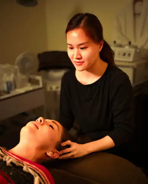 Chi Spa practitioner gently supporting a guest's head and shoulders during a hands-on wellness treatment